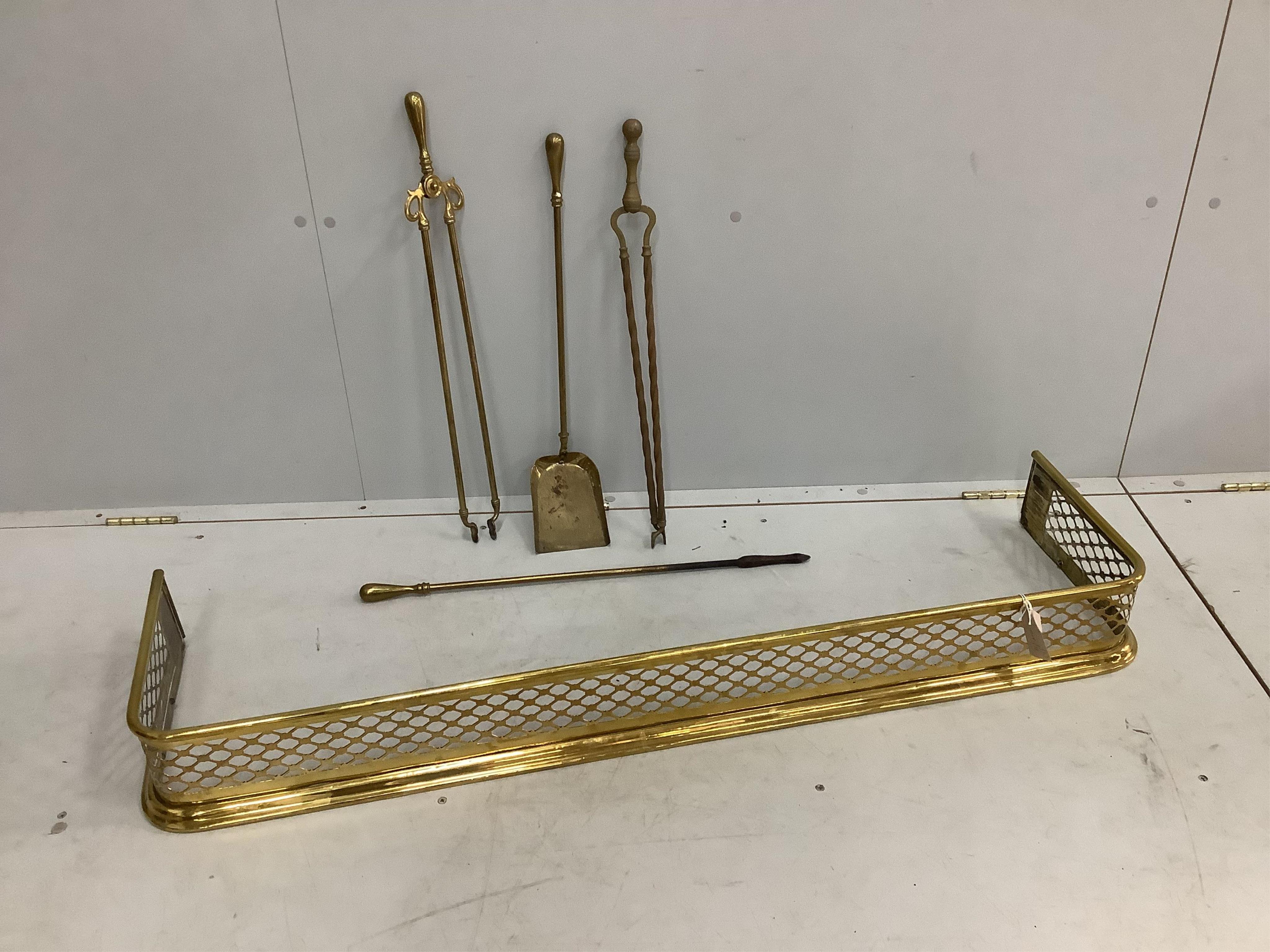 A Victorian pierced brass fender, width 123cm together with four brass fire implements. Condition - fair